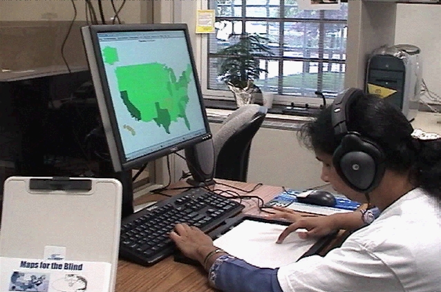 A photo of one of the user study participant: sitting at a computer, wearing headphons, and using the interface with a tablet