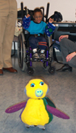 Young boy in a wheelchair controlling a yellow fuzzy robot by moving his arms