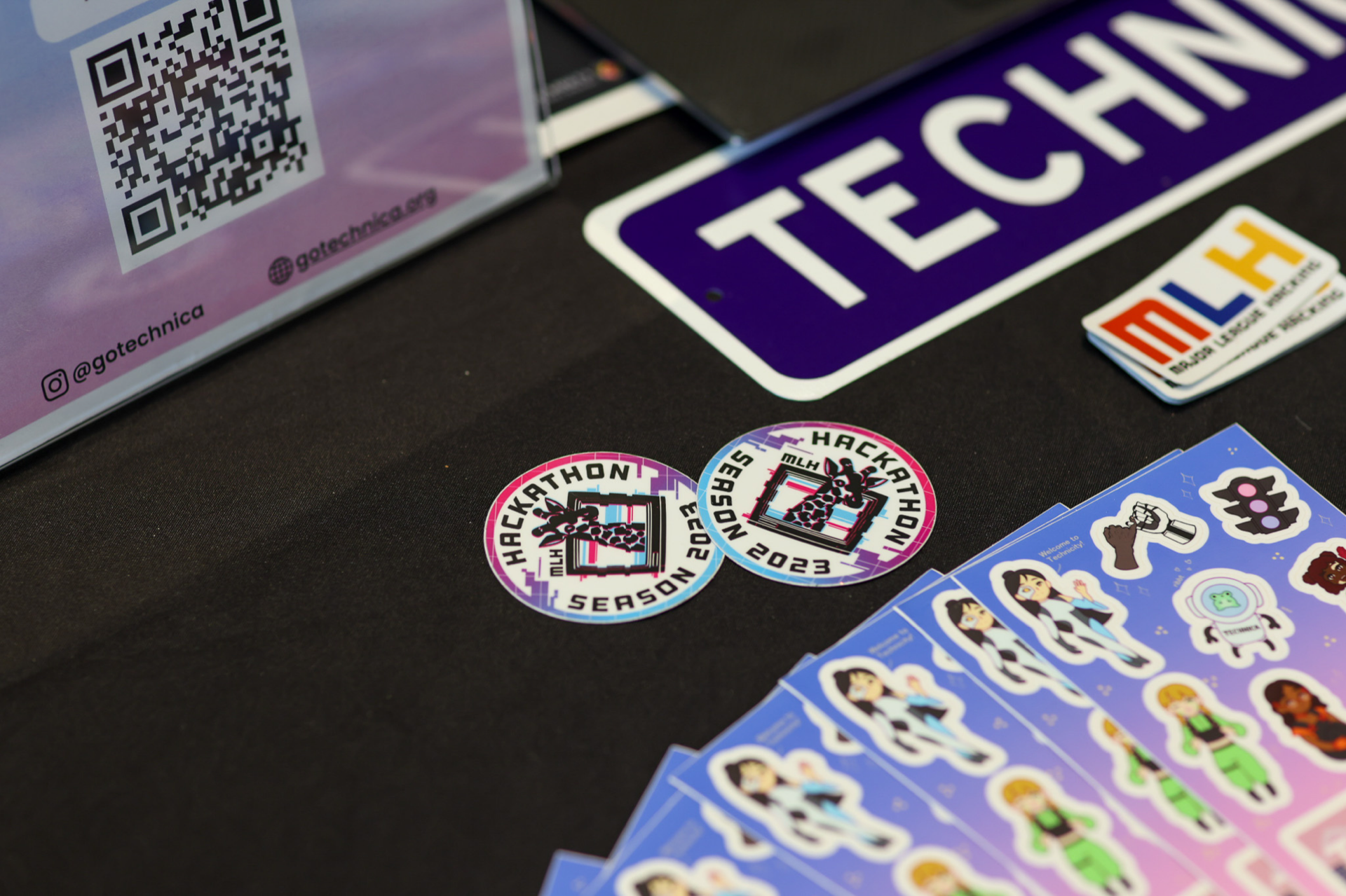 stickers on a table from various CS student organizations