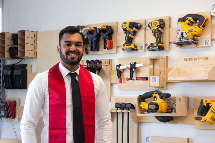 photo of Hrithik Bansal (B.S. ’22, computer science) in front of the French cleat tool wall he constructed in the Sandbox.