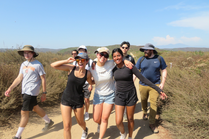 photo of Harshita Kalbhor (left), Grace Cai (center) and Neha Rajasekaran (right) hike with fellow RoboSub team members along a dirt trail during last summer's RoboSub competition in Irvine, California, in August 2024.