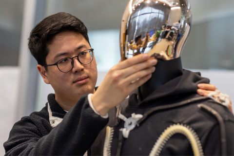 Researcher adjusting test garment on mannequin