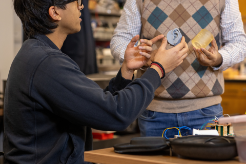 Dr. Roy examines an object with a researcher