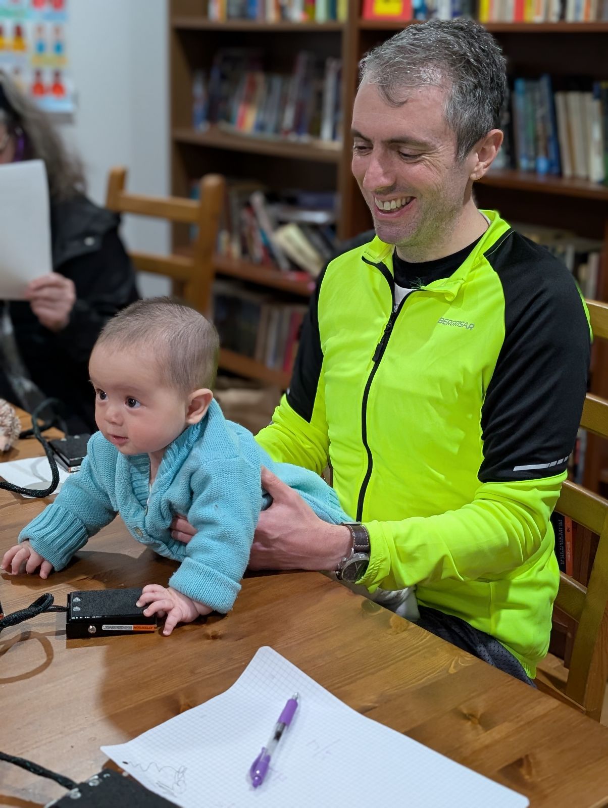 Infant leaning forward on table in front of Jordan Boyd-Graber